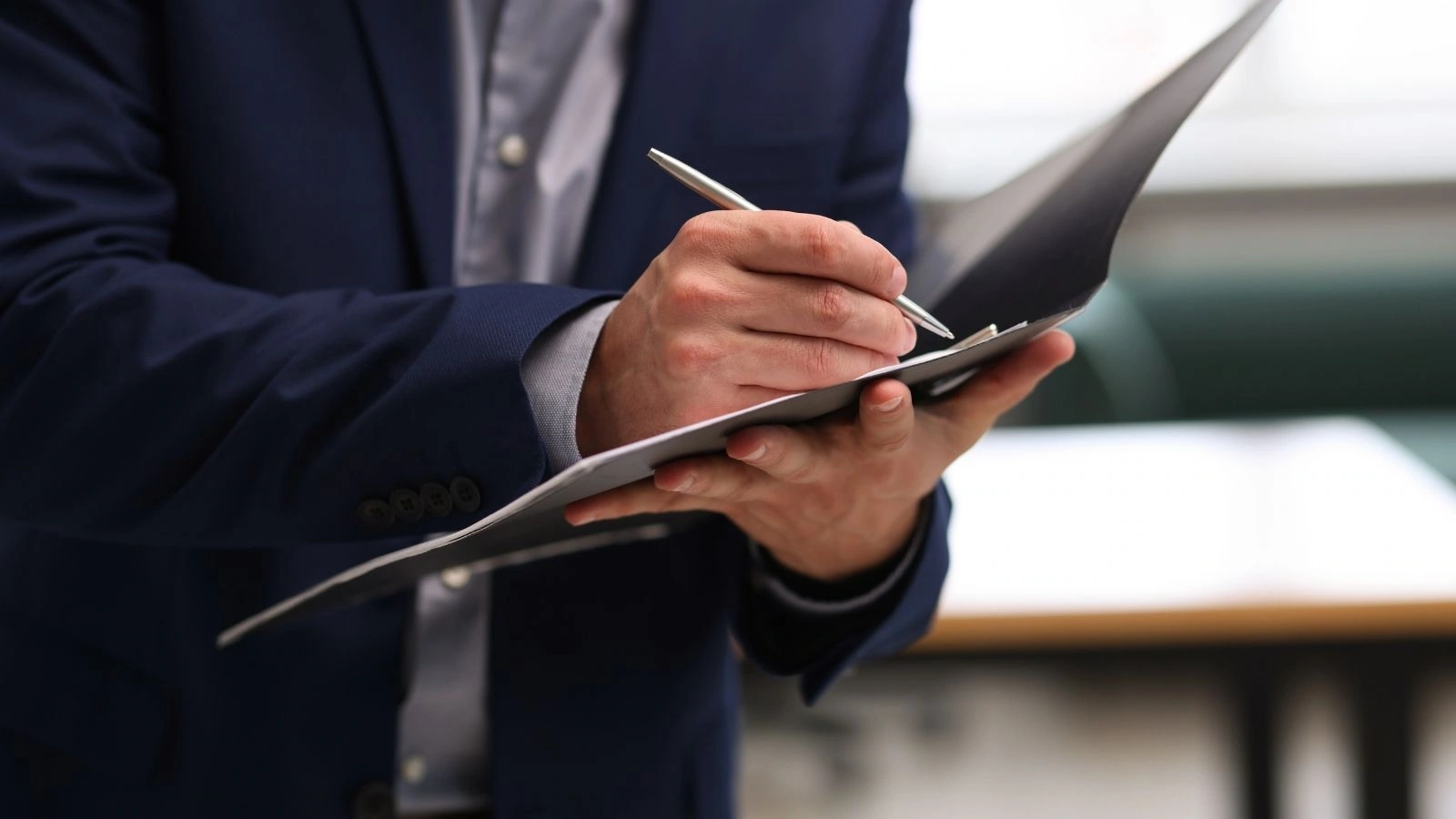 Mężczyzna odnotowujący zapis w dokumencie