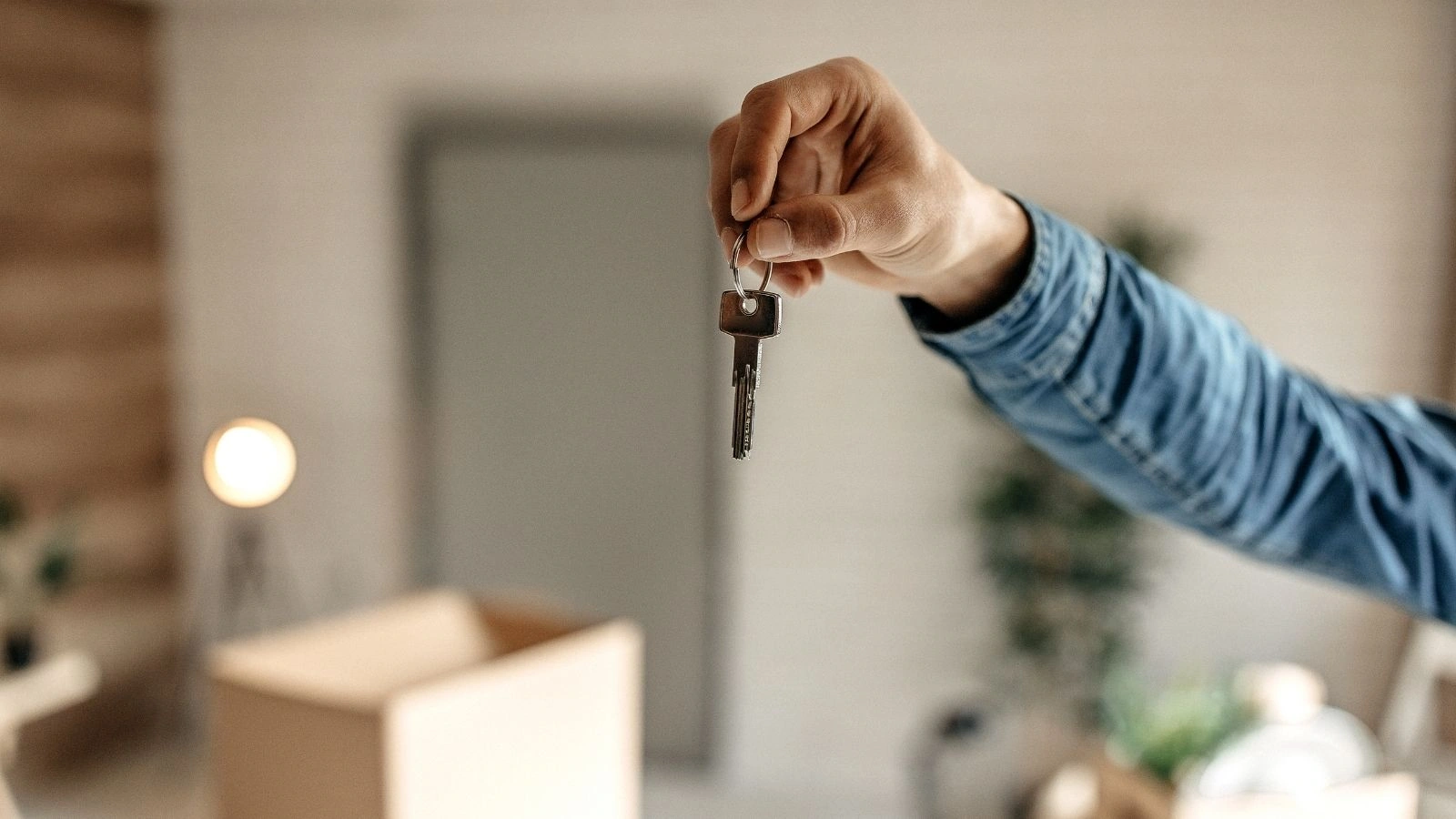 mężczyzna trzyma w ręce klucze do mieszkania